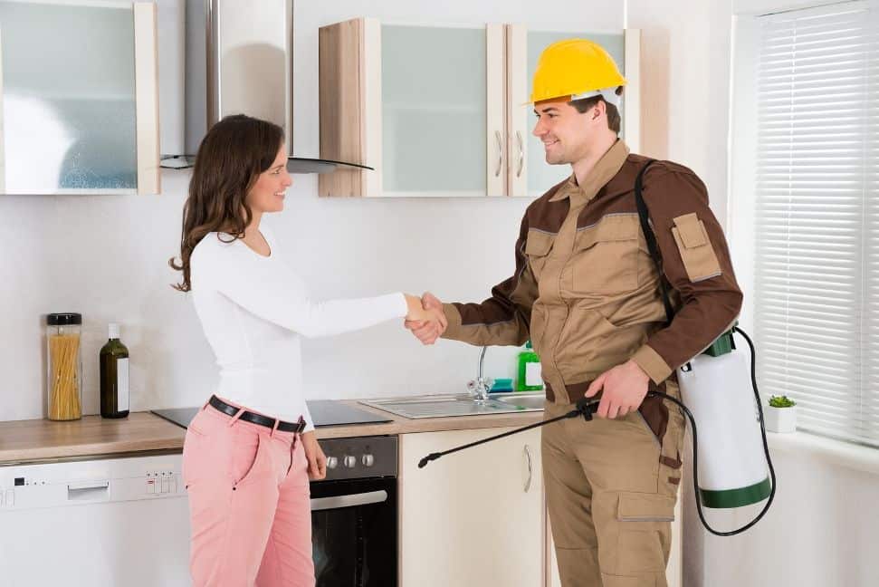 A woman shaking hands with a man in an industrial setting.